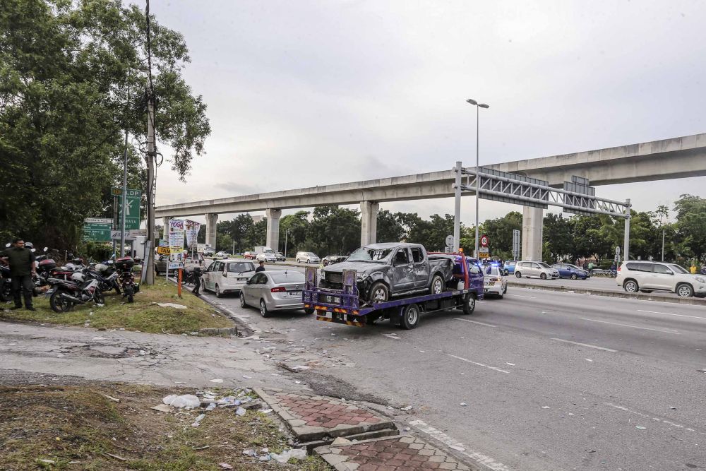 The burnt wreckage of a car is towed from the Sri Maha Mariamman Devasthanam temple November 27, 2018. u00e2u20acu2022 Picture by Firdaus Latif