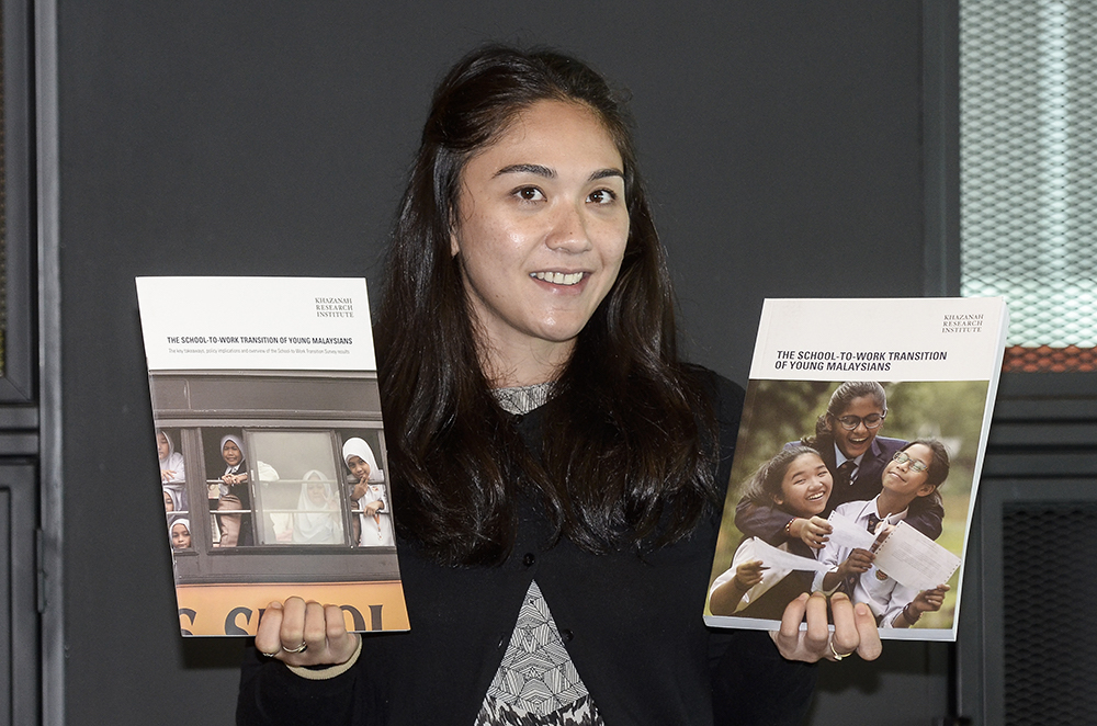 Khazanah staff, Atiqah Azlan, poses with Khazanah's 'School to Work Transition Survey Report' in Kuala Lumpur December 12, 2018. u00e2u20acu201d Picture by Miera Zulyana