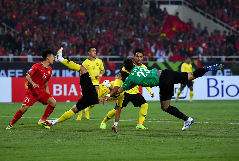 Pemain kebangsaan Mohamad Zaquan Adha Abd Radzak ketika diasak oleh penjaga gol Vietnam Dang Van Lam pada aksi perlawanan akhir kedua Kejohanan Piala AFF Suzuki 2018 di Stadium Nasional My Dinh, malam ini. u00e2u20acu201d Foto Bernama