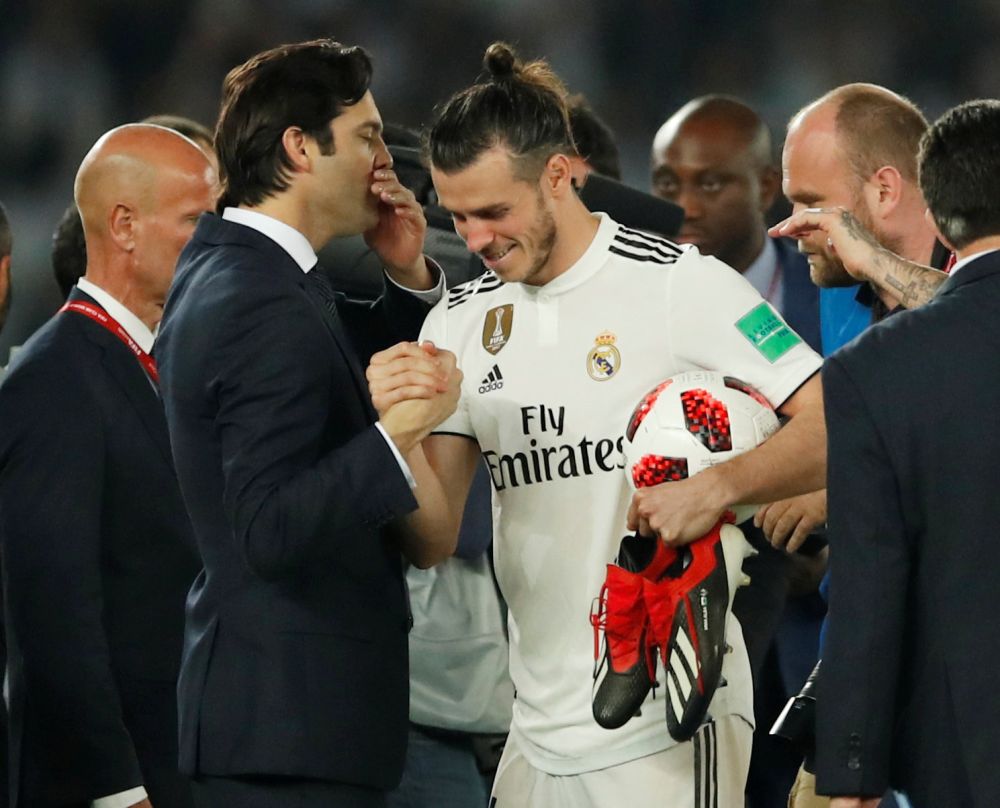 Real Madridu00e2u20acu2122s Gareth Bale shakes hands with coach Santiago Solari while holding the match ball at the end of the Club World Cup semi-final against Kashima Antlers at the Zayed Sports City Stadium, Abu Dhabi, December 19, 2018. u00e2u20acu201d Reuters pic