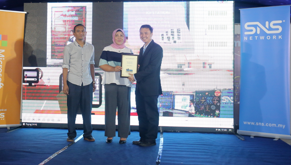 SNS Network (M) Sdn Bhd managing director Ko Yun Hung (right) receives a memento from Ipoh City councillor Puteri Holijah Muhamad Rali during the opening of Hari Edutech at Angsana Mall, Ipoh December 1, 2018. u00e2u20acu201d Picture by Farhan Najib