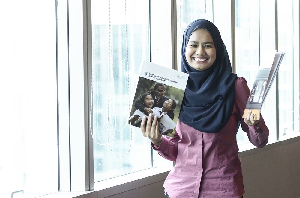 Khazanah staff, Hazwanie Abdullah, poses with Khazanah's 'School to Work Transition Survey Report' in Kuala Lumpur December 12, 2018. u00e2u20acu201d Picture by Miera Zulyana