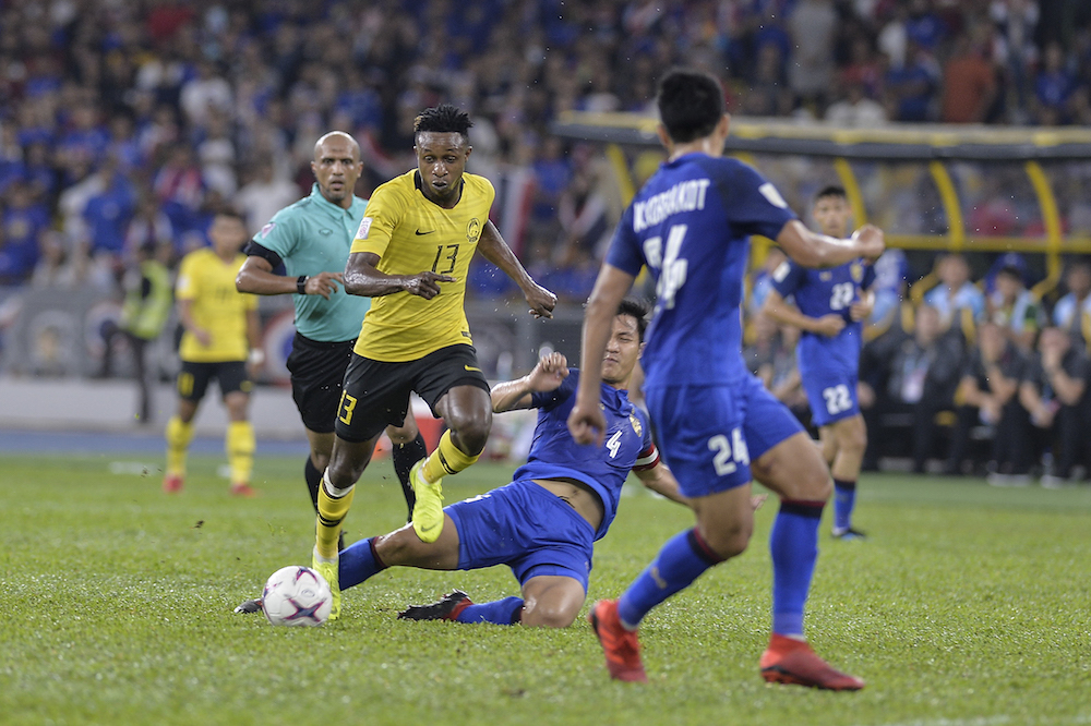 Malaysia player, Mohamdou Sumareh dribbles past, Thailand players during the AFF Suzuki Cup semi-final match between Malaysia and Thailand 2018 in National Stadium Bukit Jalil in Kuala Lumpur December 1, 2018. u00e2u20acu201d Picture by Shawan Zaidonn