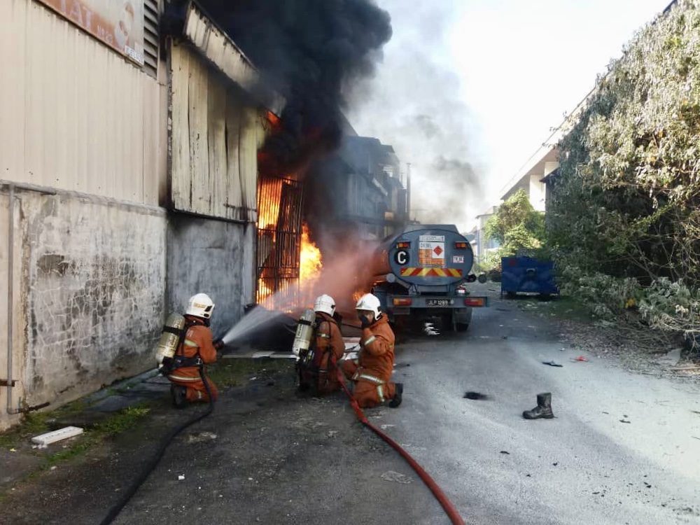Firemen contain the blaze involving a diesel tanker at a factory in Taman Mount Austin here today. u00e2u20acu201d Picture courtesy of the Johor Fire and Rescue Department 