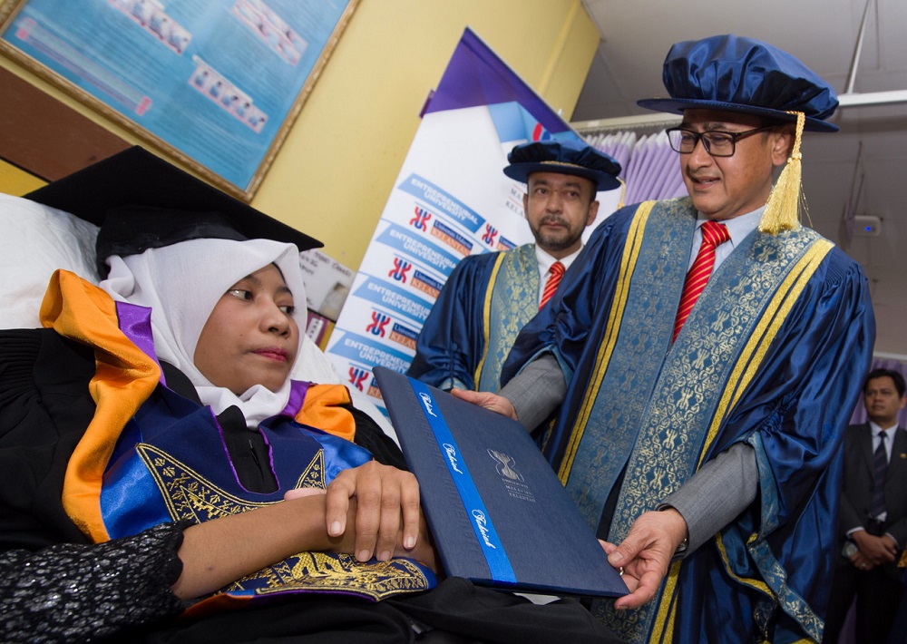 Prof Datuk Dr Husaini Omar menyampaikan skrol ijazah kepada Amirah Mohd Zahari di Wad 3 HUSM Kubang Kerian semalam. u00e2u20acu201d Foto Bernama
