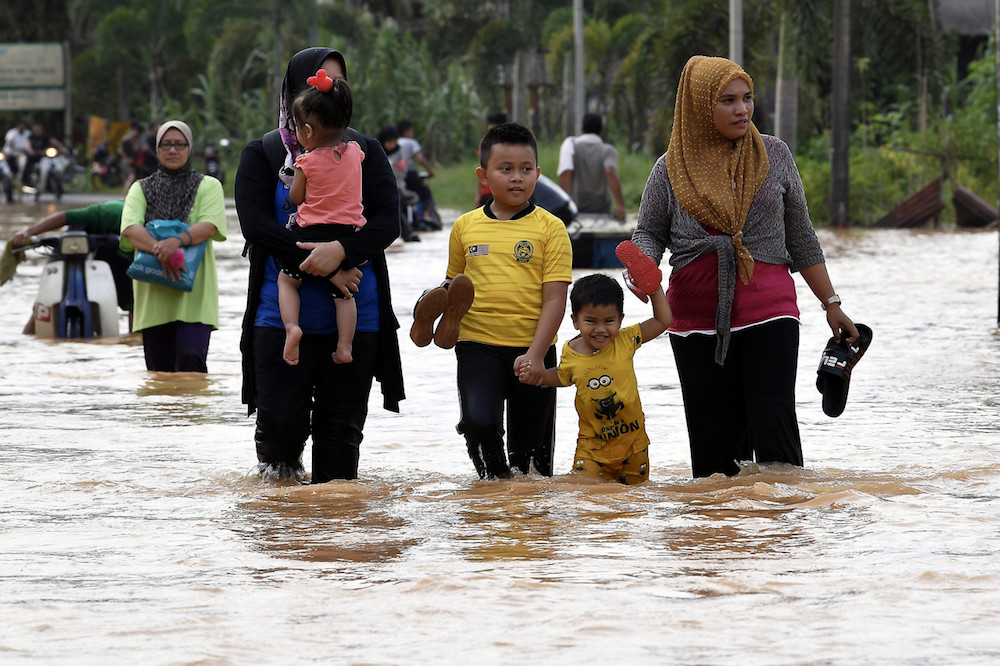Beberapa penduduk meredah banjir untuk ke pusat pemindahan sementara berdekatan selepas rumah mereka dinaiki air banjir di Kampung Matang, Hulu Terengganu hari ini. u00e2u20acu201d Foto Bernama