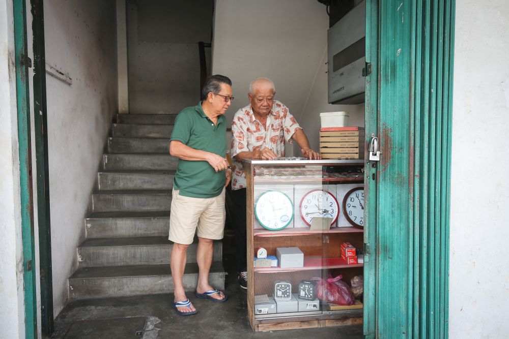 Customer Chin Yin talking to watchmaker Wong Hean Seng.
