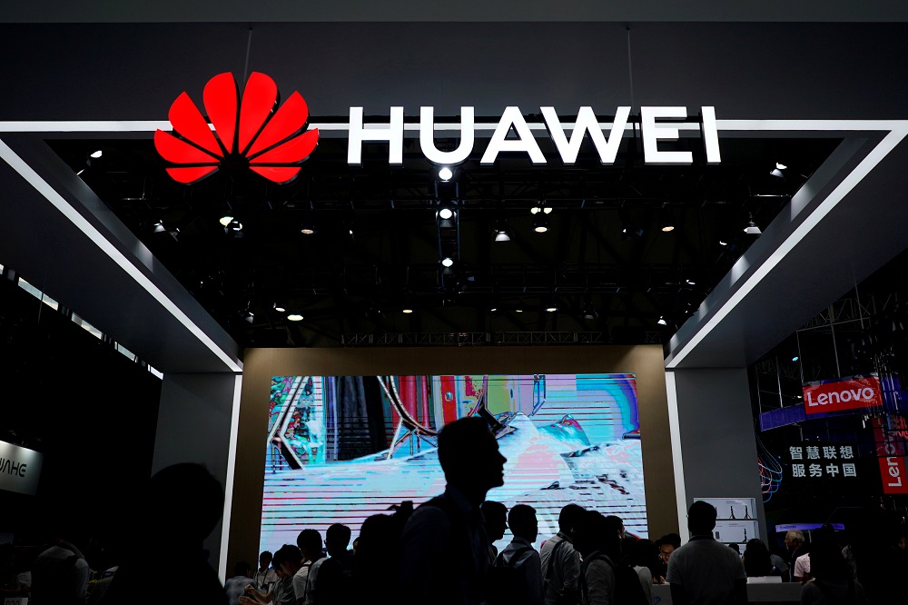 People walk past a sign board of Huawei at CES (Consumer Electronics Show) Asia 2018 in Shanghai, China June 14, 2018. u00e2u20acu201d Reuters pic