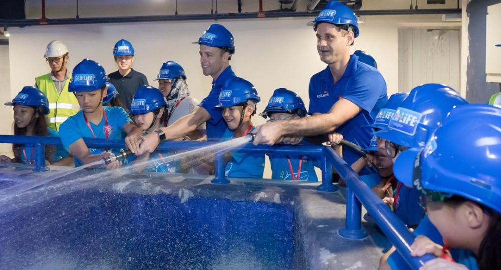 Legoland Malaysia Resort general manager Kurt Stocks (left) and Sea Life Malaysia manager Kristian Griffin filling Sea Life Malaysiau00e2u20acu2122s ocean tank with the Junior Rangers on Saturday. u00e2u20acu201d Picture courtesy of Legoland Malaysia