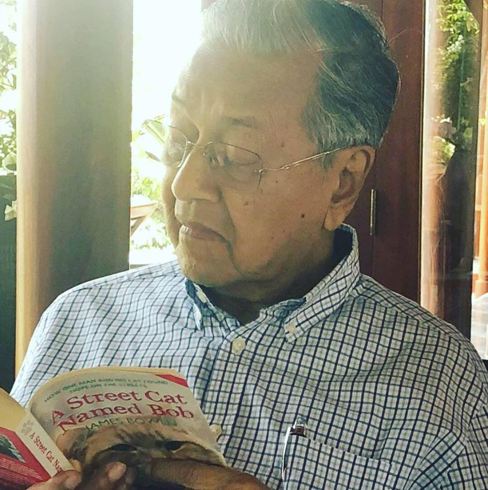Tun Dr Mahathir Mohamad reads . u00e2u20acu02dcA Street Cat named Bobu00e2u20acu2122. u00e2u20acu201d Picture via Facebook/Dr Mahathir Mohamad