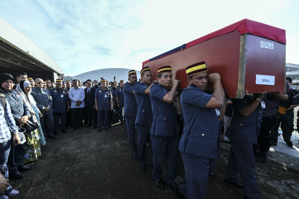 Prime Minister Tun Dr Mahathir Mohamad looks on as Fire and Rescue Department personnel carry Muhammad Adibu00e2u20acu2122s coffin to a helicopter at Subang airport December 18, 2018. u00e2u20acu201d Bernama pic