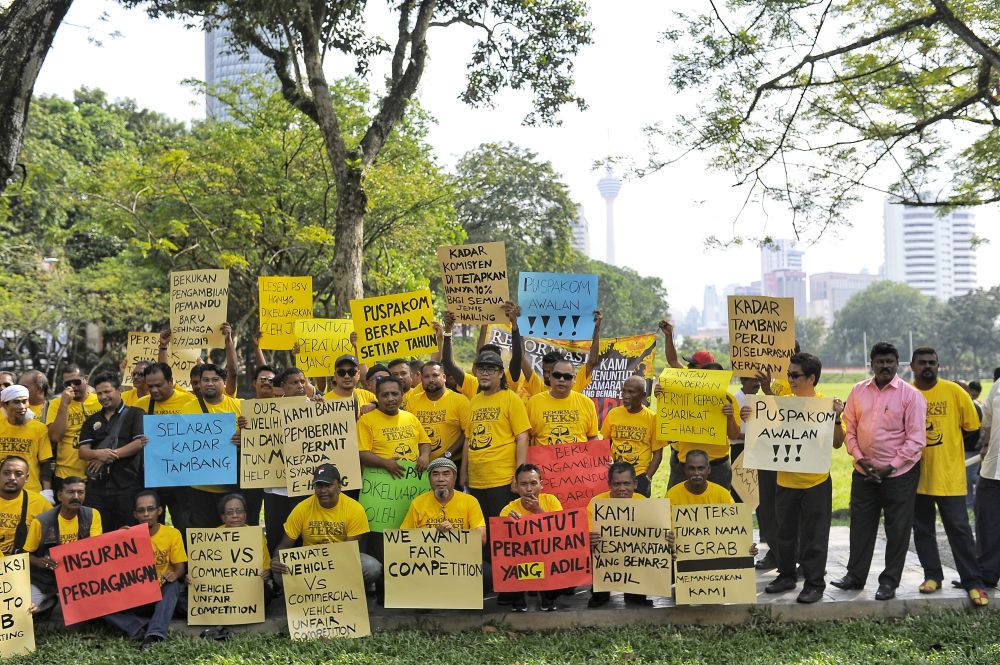 Taxi drivers hold placards during the Reformation Taxis public rally at Padang Merbok in Kuala Lumpur December 19, 2018. u00e2u20acu2022 Picture by Shafwan Zaidon