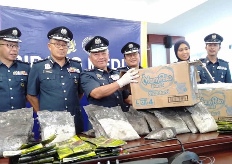 Sabah Customs deputy director Datuk Madrim Tasan (centre) with the methamphetamines (syabu) seized last Friday. u00e2u20acu201d Picture by Julia Chan