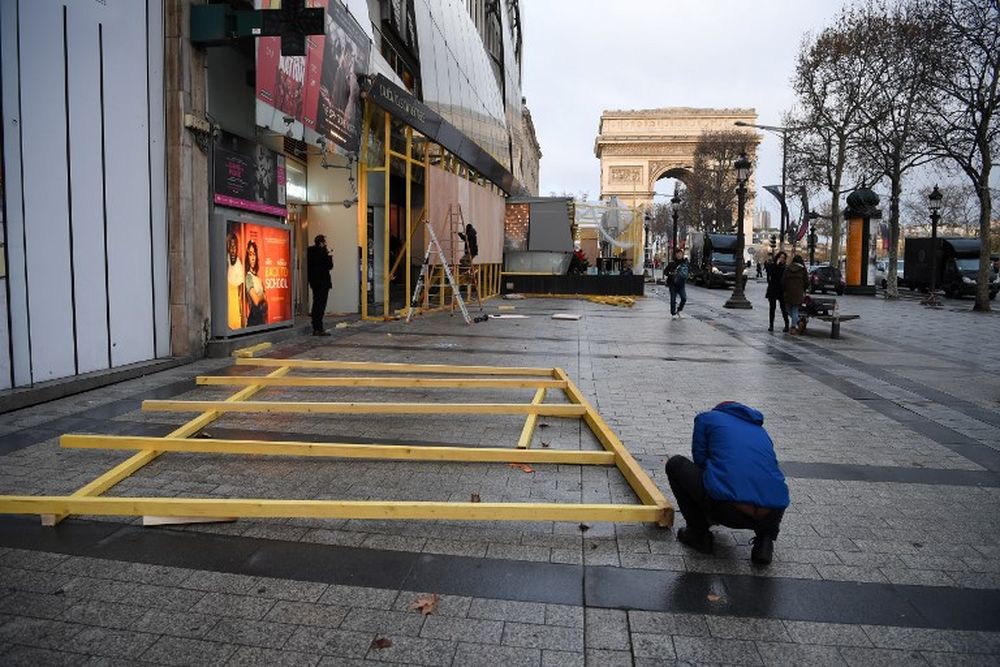 Workers remove wooden wall installed  to protect the drugstore near the Arc de Triomphe in Paris, December 9, 2018 a day after a u00e2u20acu02dcyellow vestu00e2u20acu2122 protests as part of a fourth weekend of nationwide protests. u00e2u20acu201d AFP pic