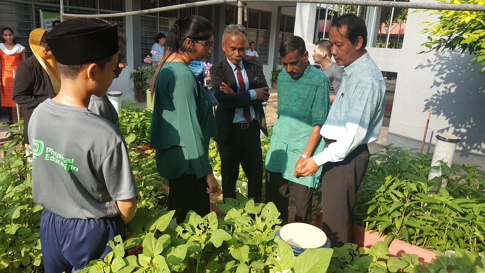 (From right) Datuk Zawawi, Subbarow and Muhammad Abdul Samad with the students inspecting the vegetable patches. u00e2u20acu201d Picture courtesy of E&O Berhad