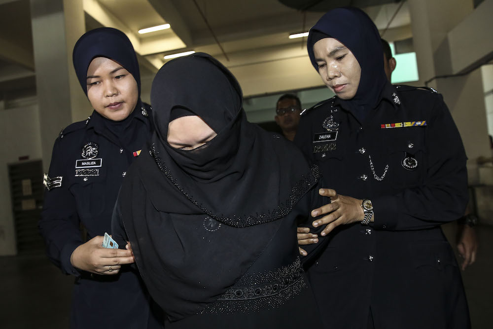 Rozita Mohamad Ali is escorted by police at Shah Alam High Court in Shah Alam March 29, 2018. u00e2u20acu201d Picture by Yusof Mat Isa