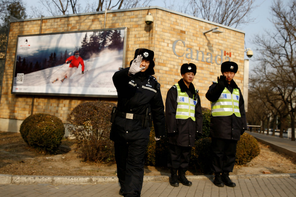 A police officer gestures at the photographer as security staff stand guard outside the Canadian embassy in Beijing December 20, 2018. u00e2u20acu201d Reuters pic