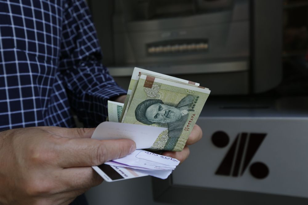 A man withdraws Iranian Rial notes from an automated teller machine in the capital Tehran July 31, 2018. u00e2u20acu201d AFP pic