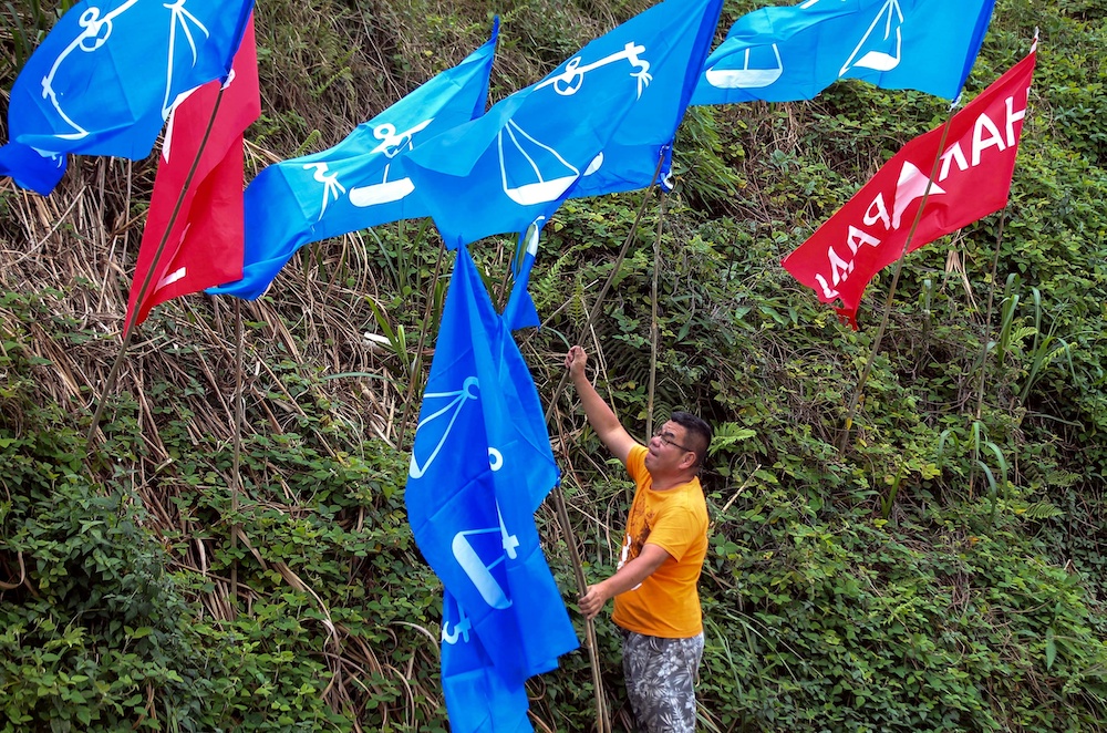 A Barisan Nasional supporter putting up flags of the coalition in Tringkap January 20, 2019. u00e2u20acu201d Picture by Farhan Najib