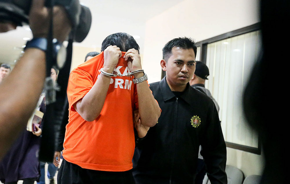 A state government department director is escorted by MACC officers to the George Town Magistrates Court January 8, 2019. u00e2u20acu201d Picture by Sayuti Zainudin