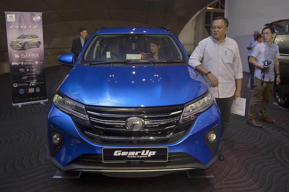 People check out the new Perodua Aruz during its official launch at MITEC in Kuala Lumpur January 15, 2018. — Picture by Mukhriz Hazim