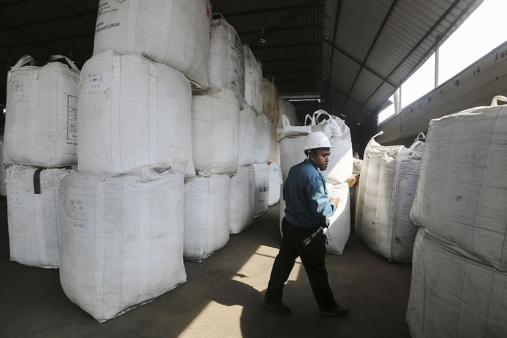 An Environmental Department officer examines plastic waste at an illegal recycling factory in Klang January 17, 2019. — Picture by Yusof Mat Isa