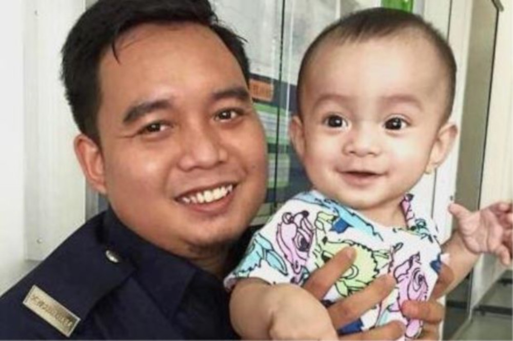 The 10-month-old baby boy with his father. — Picture via Facebook