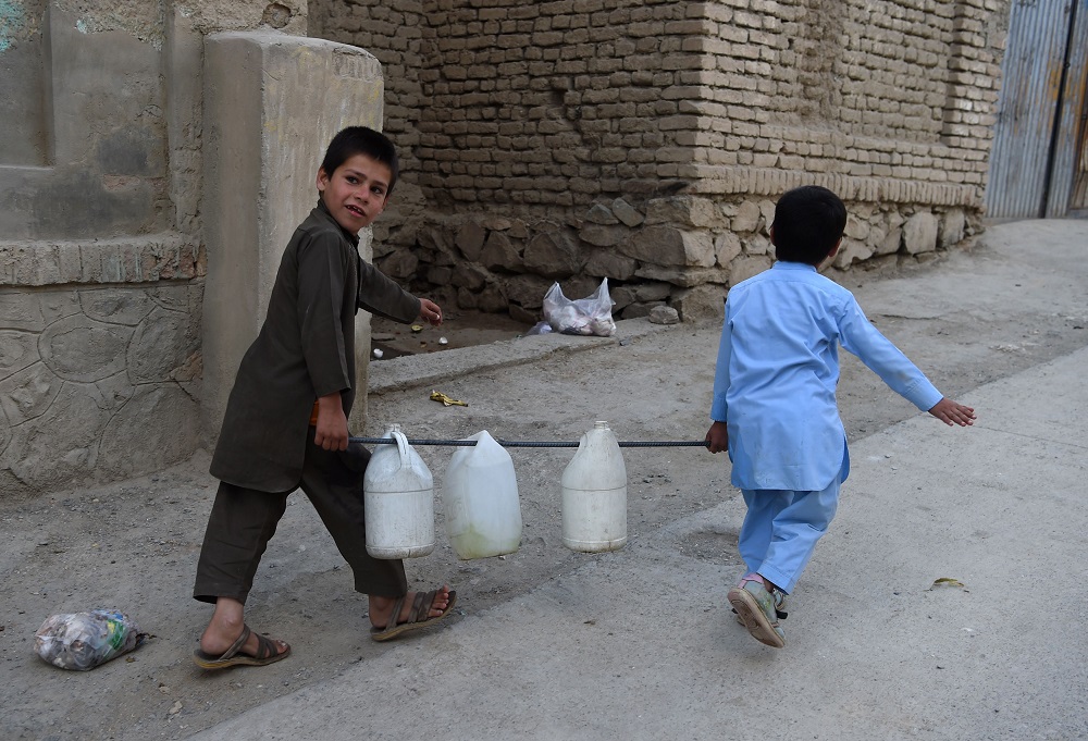 This photo taken on October 25, 2018, shows Afghan boys carrying containers of water to their home in Kabul. u00e2u20acu201d AFP pic        