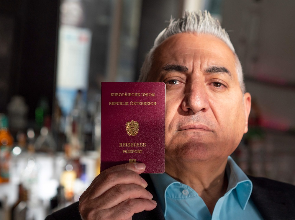 Alper Yilmaz poses with his Austrian passport at his cafe restaurant in Vienna, Austria October 31, 2018. u00e2u20acu201d AFP pic