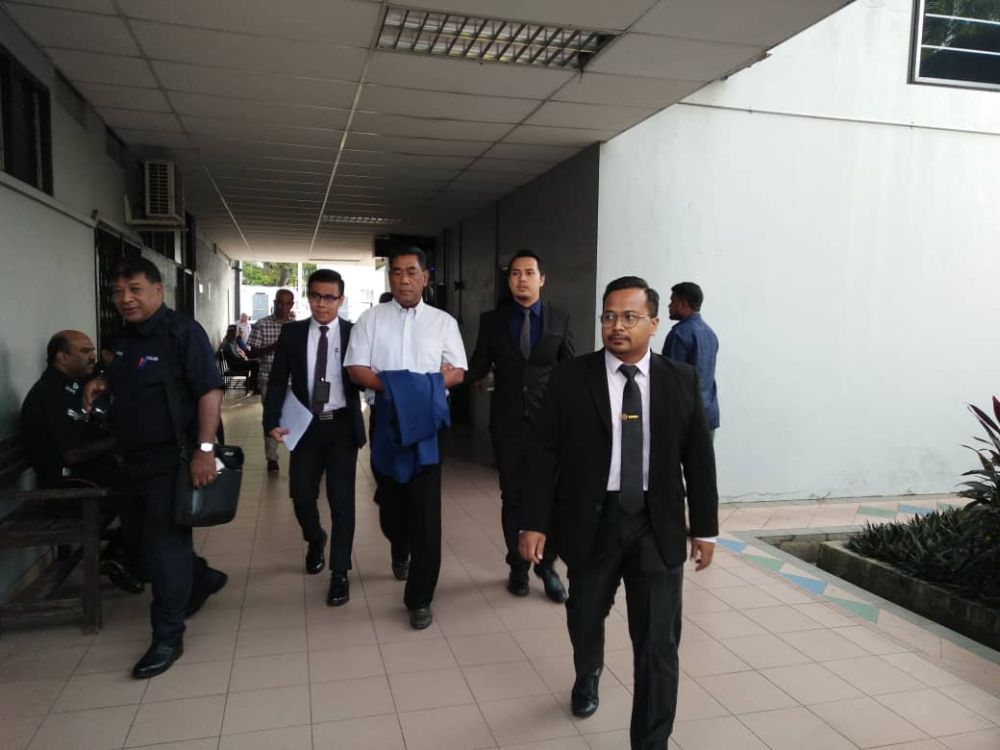 Former Perak Corp Berhad group CEO Datuk Aminuddin Md Desa (centre) is flanked by MACC officers arriving at the Sessions Court in Ipoh January 10, 2019.