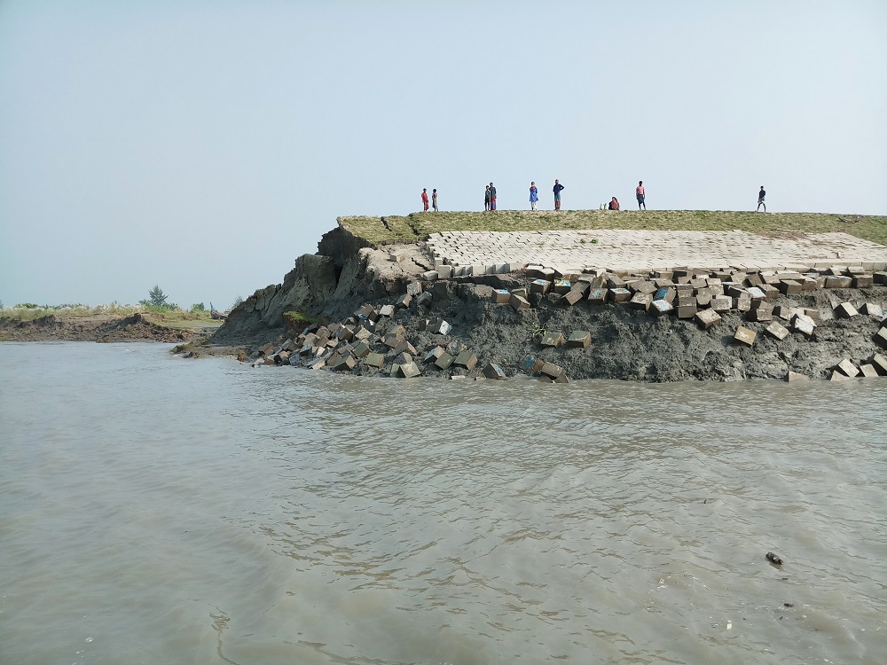 Islanders stand on an embankment on Hatiya Island that is crumbling into the sea due to erosion in Noakhali District, Bangladesh October 22, 2018. u00e2u20acu201d Thomson Reuters Foundation pic  