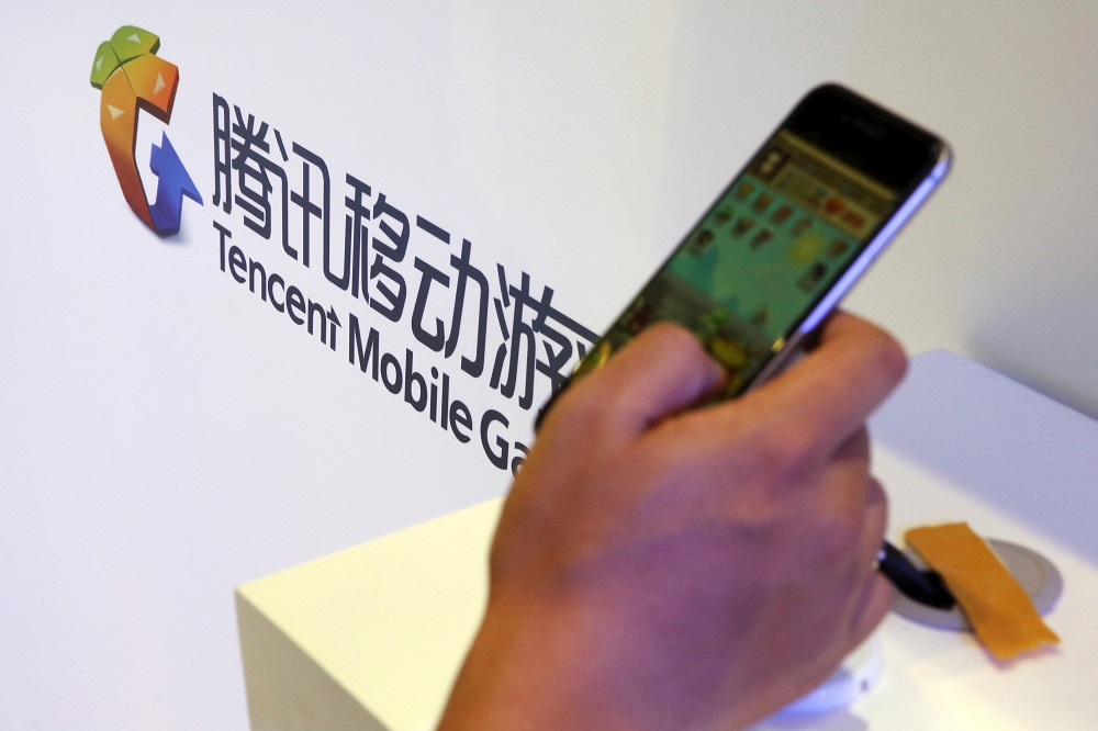A visitor plays a game on a smartphone at Tencentu00e2u20acu2122s exhibition booth at the Global Mobile Internet Conference (GMIC) 2015 in Beijing, China, April 28, 2015. u00e2u20acu201d Reuters pic     