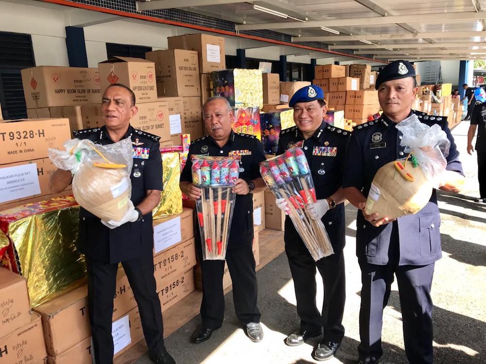 Johor police chief Datuk Mohd Khalil Kader Mohd (far left) holds a smuggled firework with other senior officers at the Region Two marine police base in Tampoi, Johor Baru today. u00e2u20acu201d Picture by Ben Tan