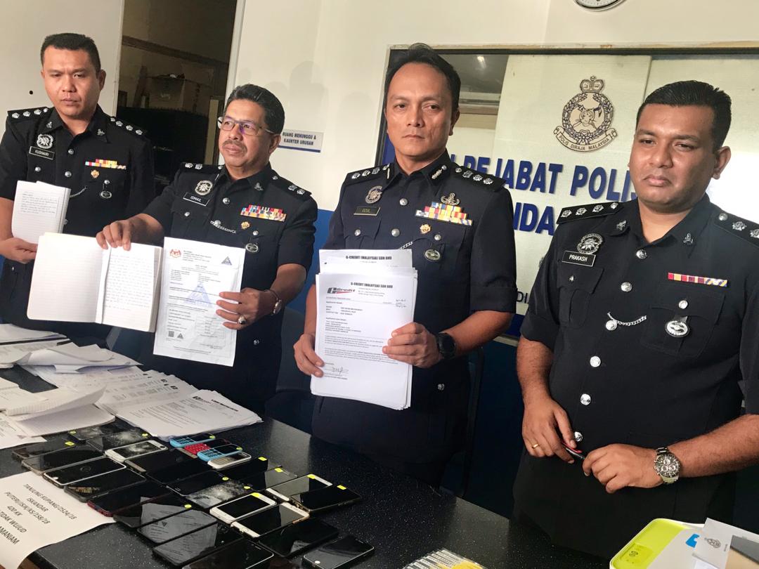 Iskandar Puteri police chief Assistant Commissioner Dzulkhairi Mukhtar (third from left) shows the fake documents used in the scam at the Iskandar Puteri district police headquarters in Nusa Bestari today. u00e2u20acu201d Picture by Ben Tan