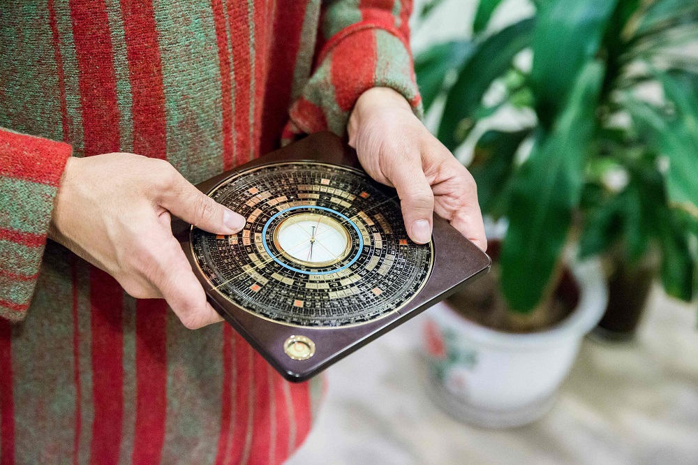This picture taken on January 19, 2019 shows feng shui master Alion Yeo holding a luopan, or Chinese compass, in his office in Hong Kong ahead of the Lunar New Year of the Pig. u00e2u20acu201d AFP pic       