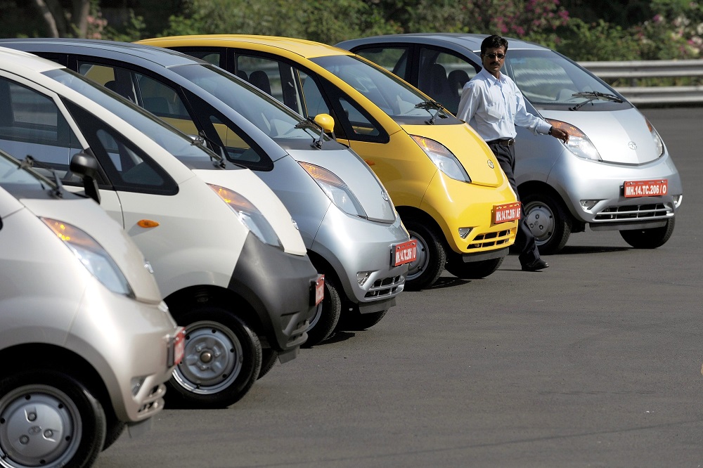 In this file photo taken on March 25, 2009, a Tata Motors employee walks past Nano cars lined up on a test track ahead of a test drive session at the Tata Motors plant at Pimpri, some 160km southeast of Mumbai. u00e2u20acu201d AFP pic 