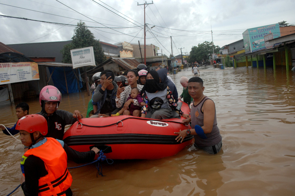 Rescue workers push an inflatable boat as they evacuate residents following floods in Makassar, South Sulawesi, Indonesia, January 23, 2019 in this photo taken by Antara Foto. u00e2u20acu201d Antara Foto/Abriawan Abhe handout pic via Reuters 