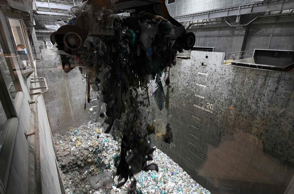 This photo taken on January 18, 2019, shows an enormous crane picking up rubbish for incineration at a combustible waste pit at the Musashino Clean Centre in Tokyo. — AFP pic