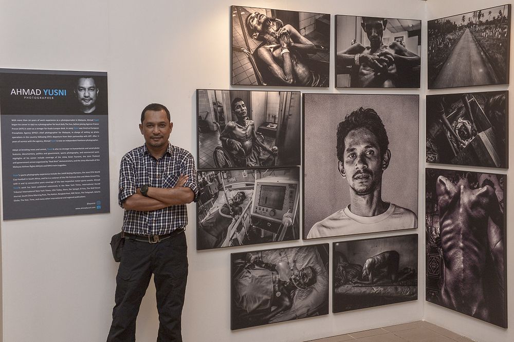 Ahmad Yusni with photographs that he has taken of his brother Mohamad Sani. The photos are included in the Outshine exhibition. u00e2u20acu201d Picture by Mukhriz Hazim