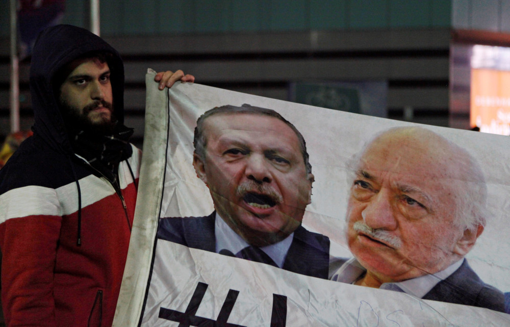 A demonstrator hold pictures of Turkeyu00e2u20acu2122s Prime Minister Reccep Tayyip Erdogan and Turkish cleric Fethullah Gulen, during a protest against Turkeyu00e2u20acu2122s ruling AK Party, in Istanbul December 30, 2013. u00e2u20acu201d Reuters pic 