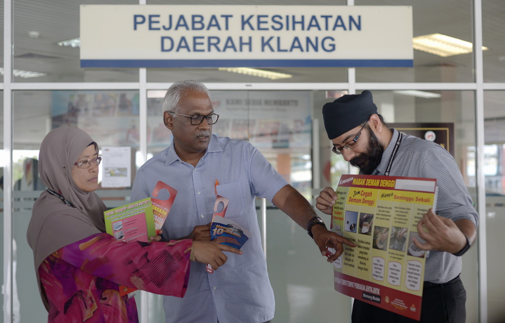 Charles Santiago (tengah) mendengar penerangan daripada Pegawai Kesihatan Daerah Klang, Dr Masitah Mohamed (kiri) berkaitan risalah membanteras nyamuk Aedes. u00e2u20acu201d Foto Bernama