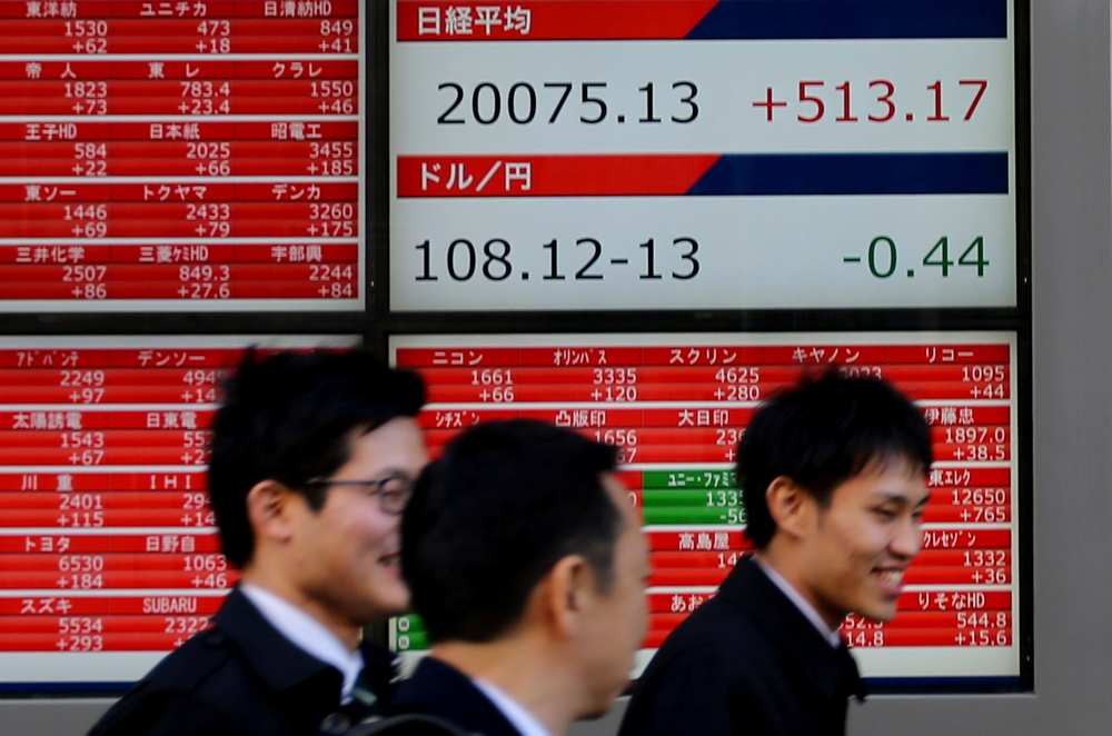 Pedestrians walk past electronic board showing the Nikkei stock index outside a brokerage in Tokyo January 7, 2019.  u00e2u20acu201d Reuters pic