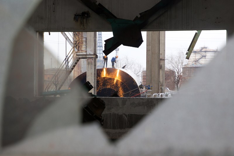 Labourers working on dismantling equipment and facilities are seen through a window at a former steel mill of Jigang, in Jinan, Shandong province, China December 27, 2018. 
