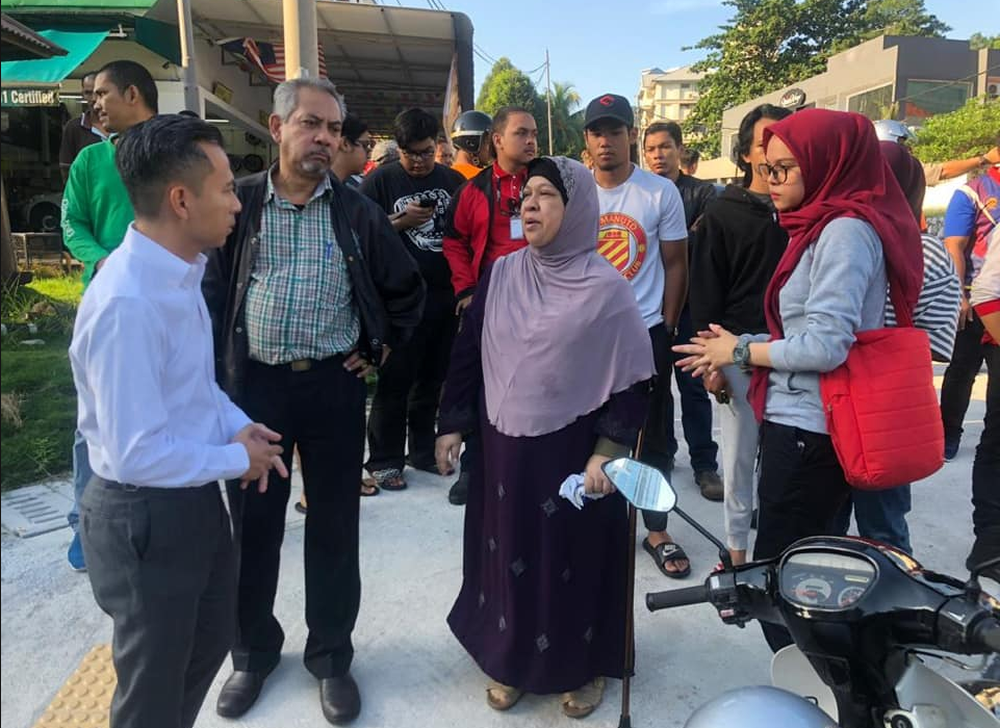 Fahmi Fadzil (left) is pictured with the parents of the deceased. u00e2u20acu201d Picture via Facebook