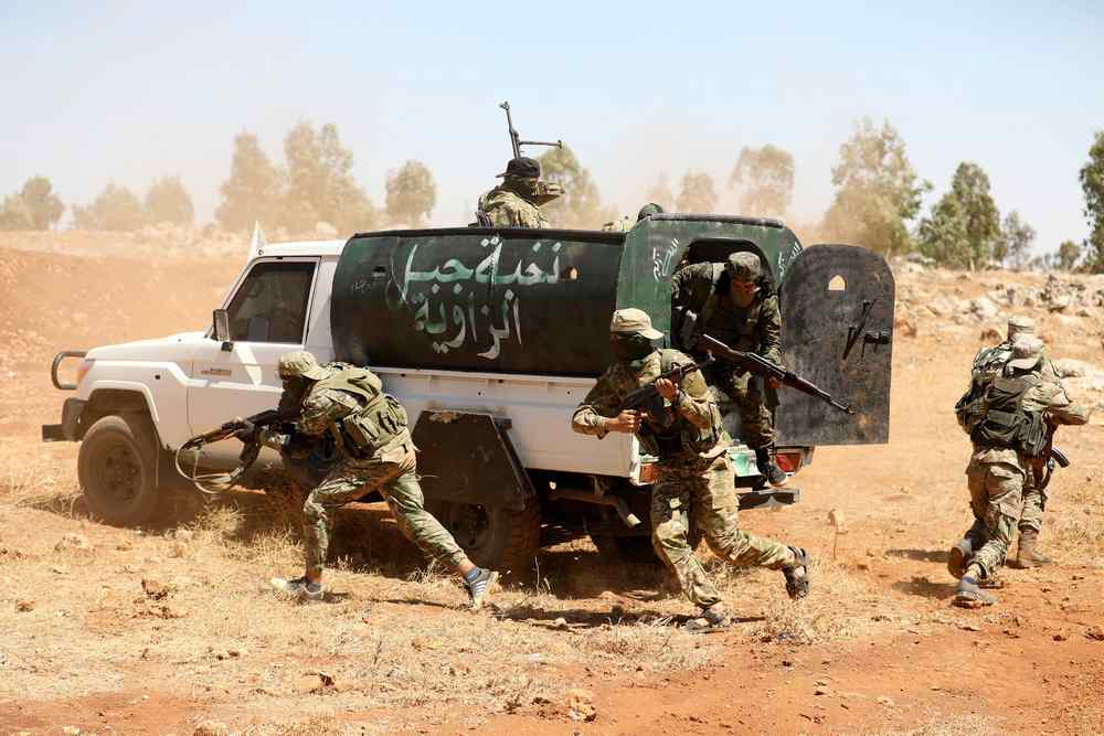 Syrian fighters attend a mock battle during a graduation of new Hayat Tahrir al-Sham (HTS) members at a camp in the countryside of the northern Idlib province August 14, 2018. u00e2u20acu201d AFP pic 