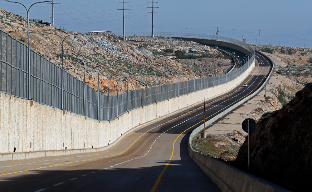 Cars drive on a new Israeli road divided by a wall to separate it for Palestinians (left) and the side to be used exclusively by Israelis and settlers (right), in east Jerusalem, on January 10, 2019. u00e2u20acu201d AFP pic