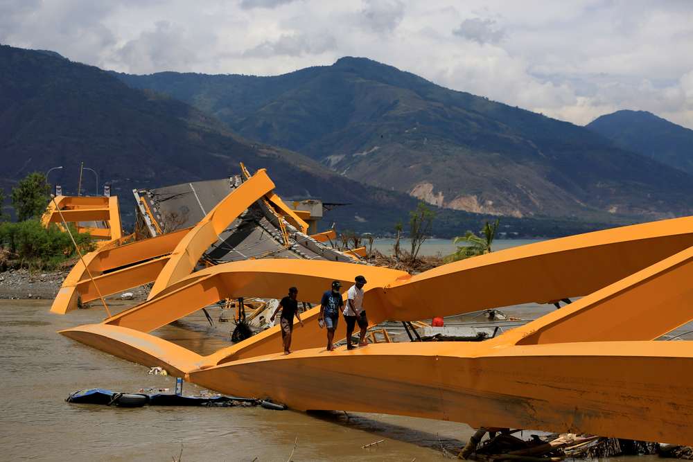 People walk on a broken bridge after it was hit by an earthquake and tsunami last week in Palu, Sulawesi island, Indonesia October 7, 2018. Indonesia is one of the world's most quake-prone countries. u00e2u20acu201d Reuters pic