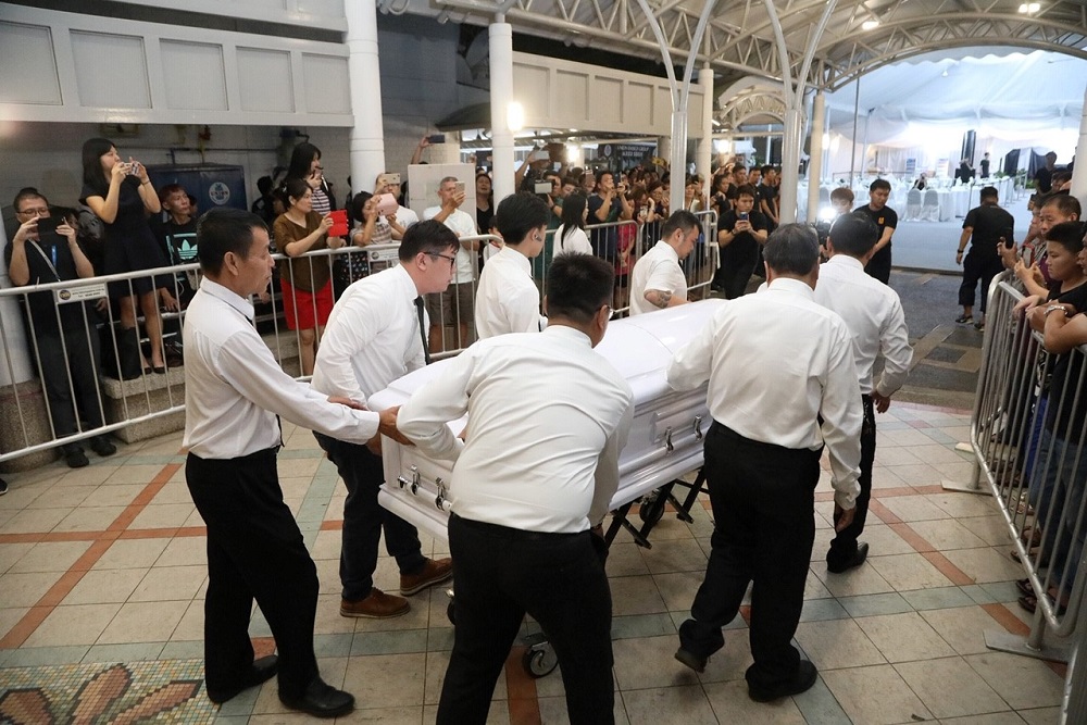 Aloysius Pang's coffin being wheeled into the tent.