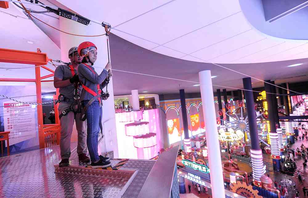 A theme park guest waits for her turn to go on the zipline.