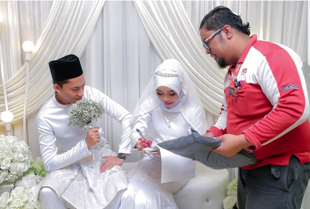 A diligent postman from Poslaju interrupts wedding ceremony to deliver parcel to the bride. u00e2u20acu201c Picture via Instagram